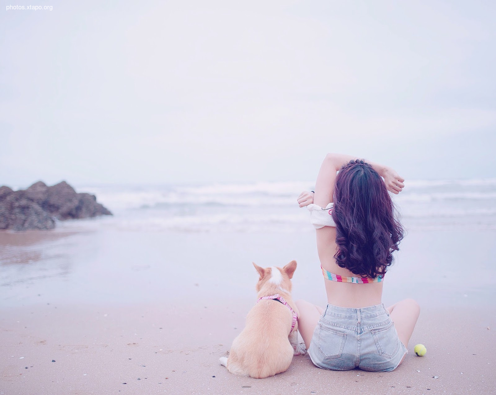 Woman relaxing on the beach with her dog.