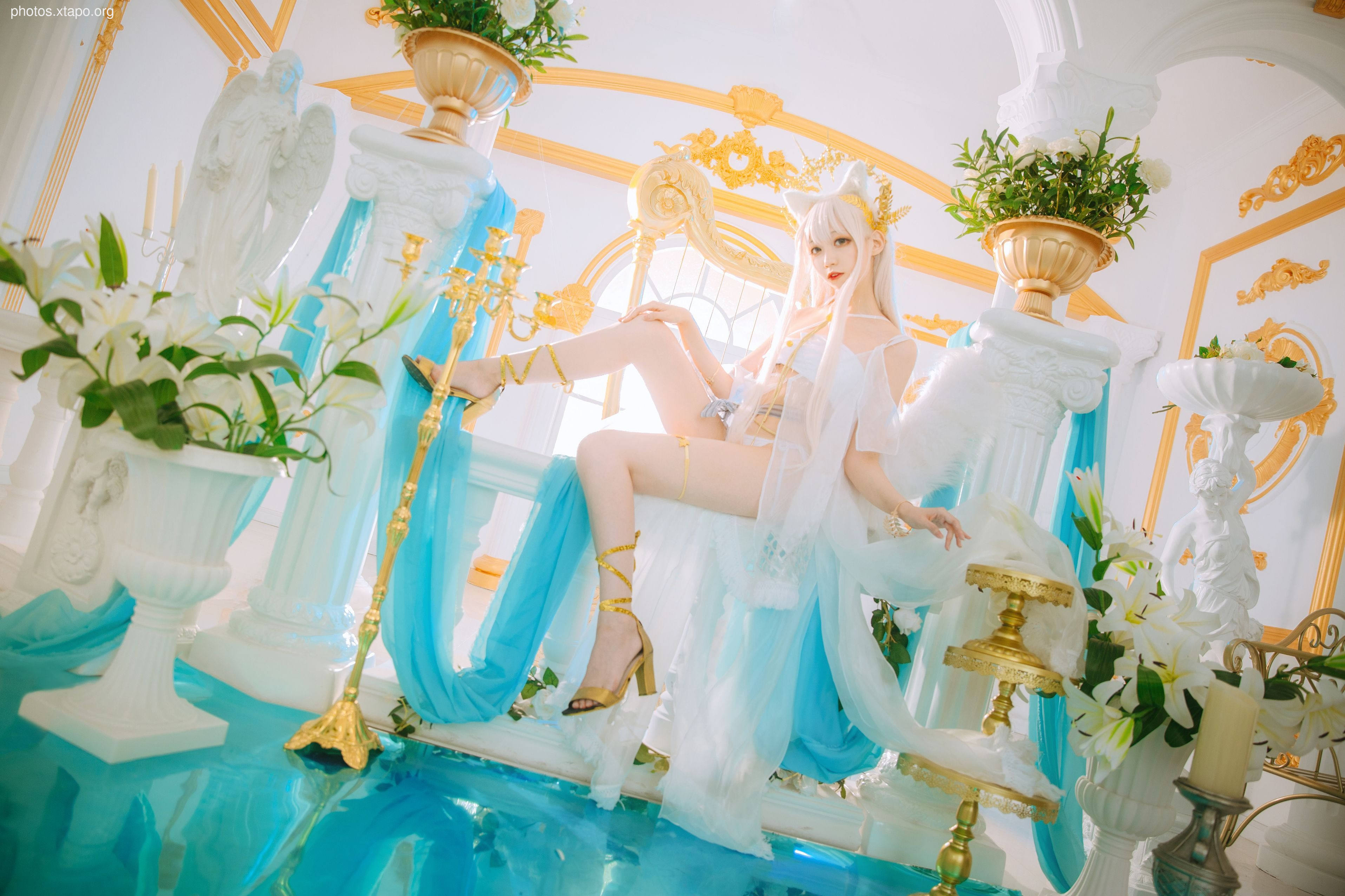 A captivating cosplay photoshoot of a goddess, elegantly posed in a flowing, ethereal gown amidst a serene, aquatic-themed setting.