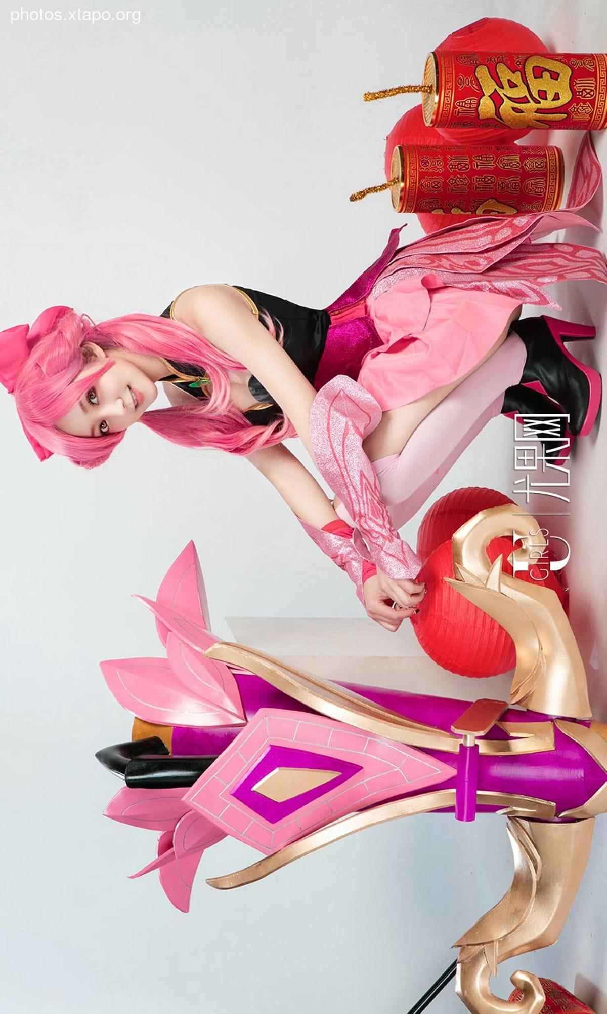 A captivating cosplay showcasing a female archer in a vibrant pink and gold costume, adorned with festive Chinese firecrackers.  The model poses with a meticulously crafted prop bow and arrow.