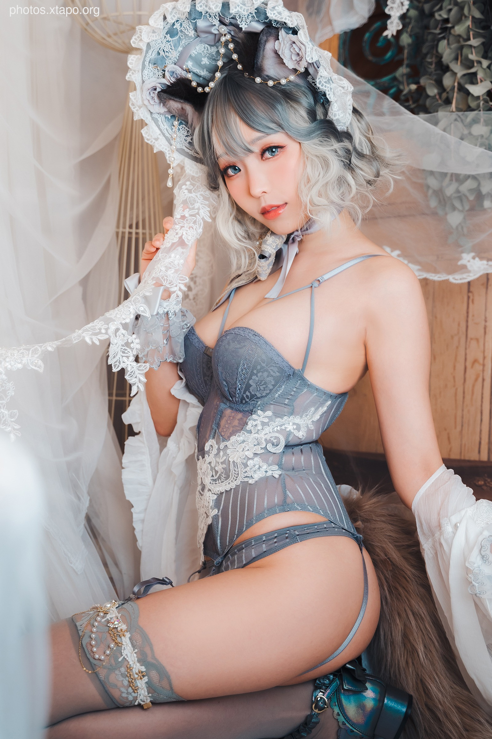 A model poses in elegant grey lace lingerie and a whimsical hat, creating a captivating and alluring image.