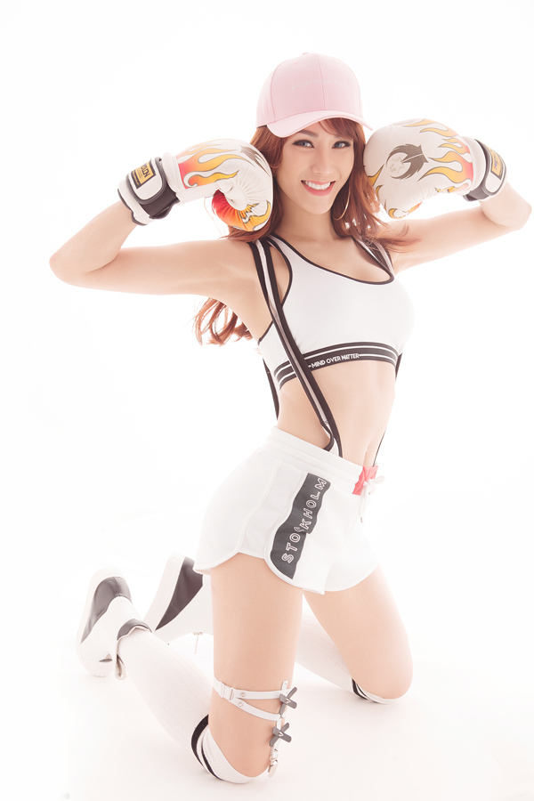 A young woman in boxing gear kneels, showcasing her athleticism and determination.