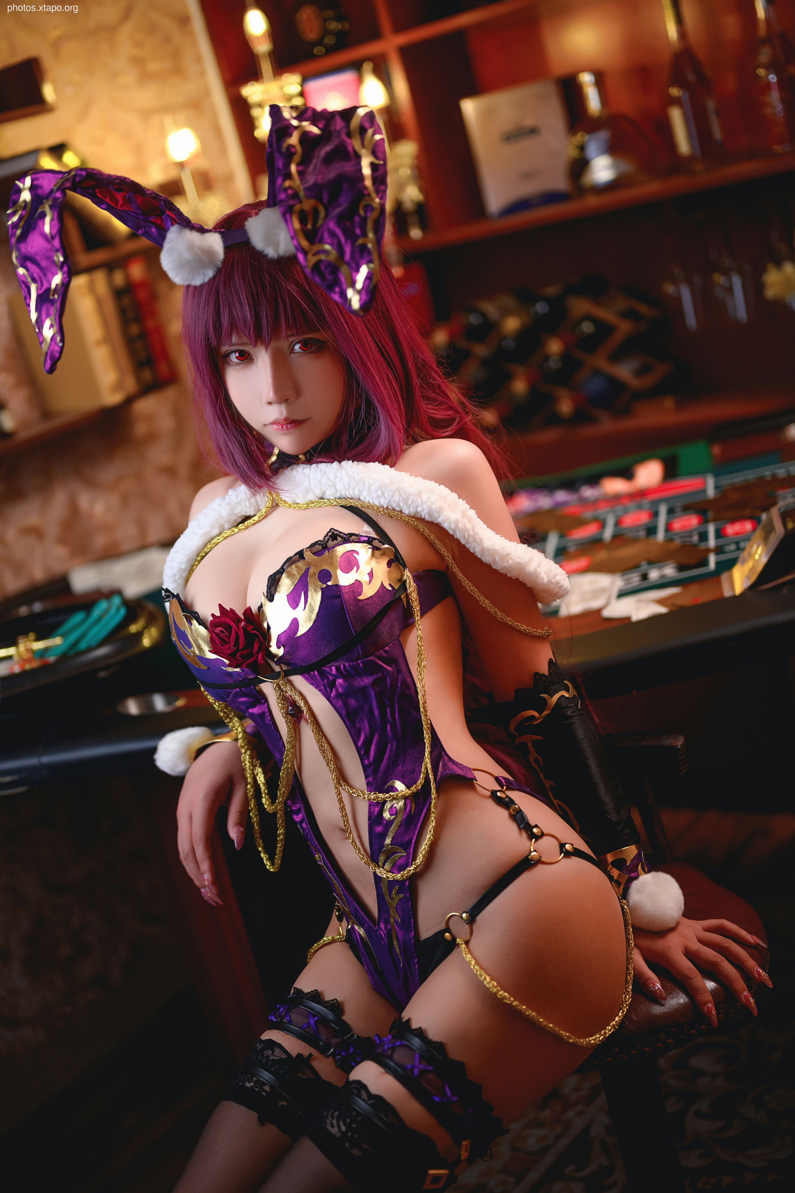 A stunning cosplay of a bunny girl in a purple and gold outfit. She is posing in a casino setting, adding a touch of mystery and intrigue.