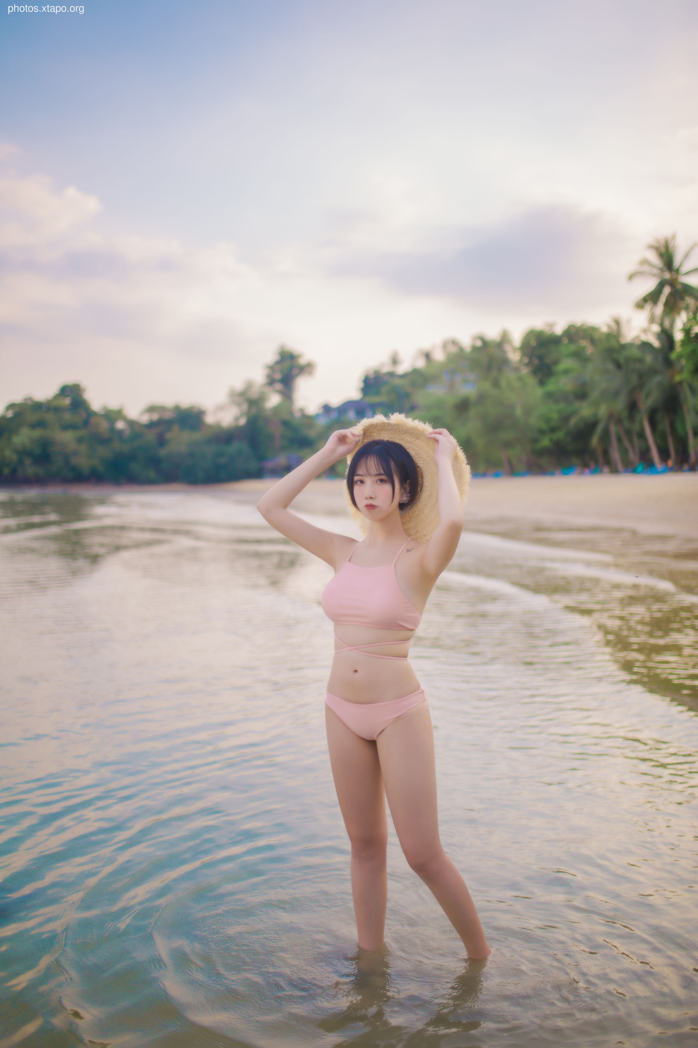 A young woman in a pink bikini enjoys a day at the beach.
