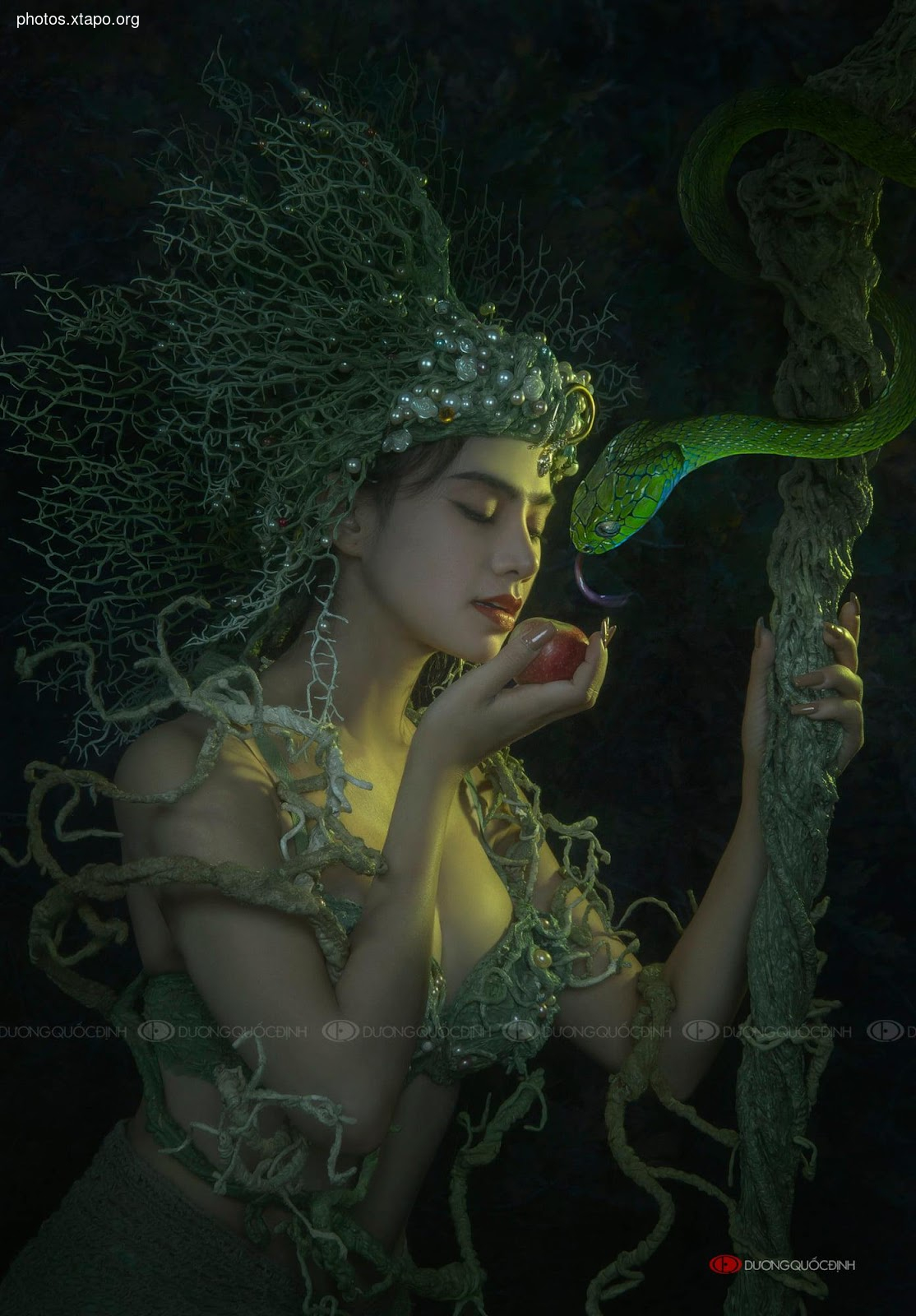 A woman adorned in ethereal seaweed and pearls, delicately holds a forbidden apple, watched by a serpent coiled around a mystical staff.  A captivating image of temptation and allure.