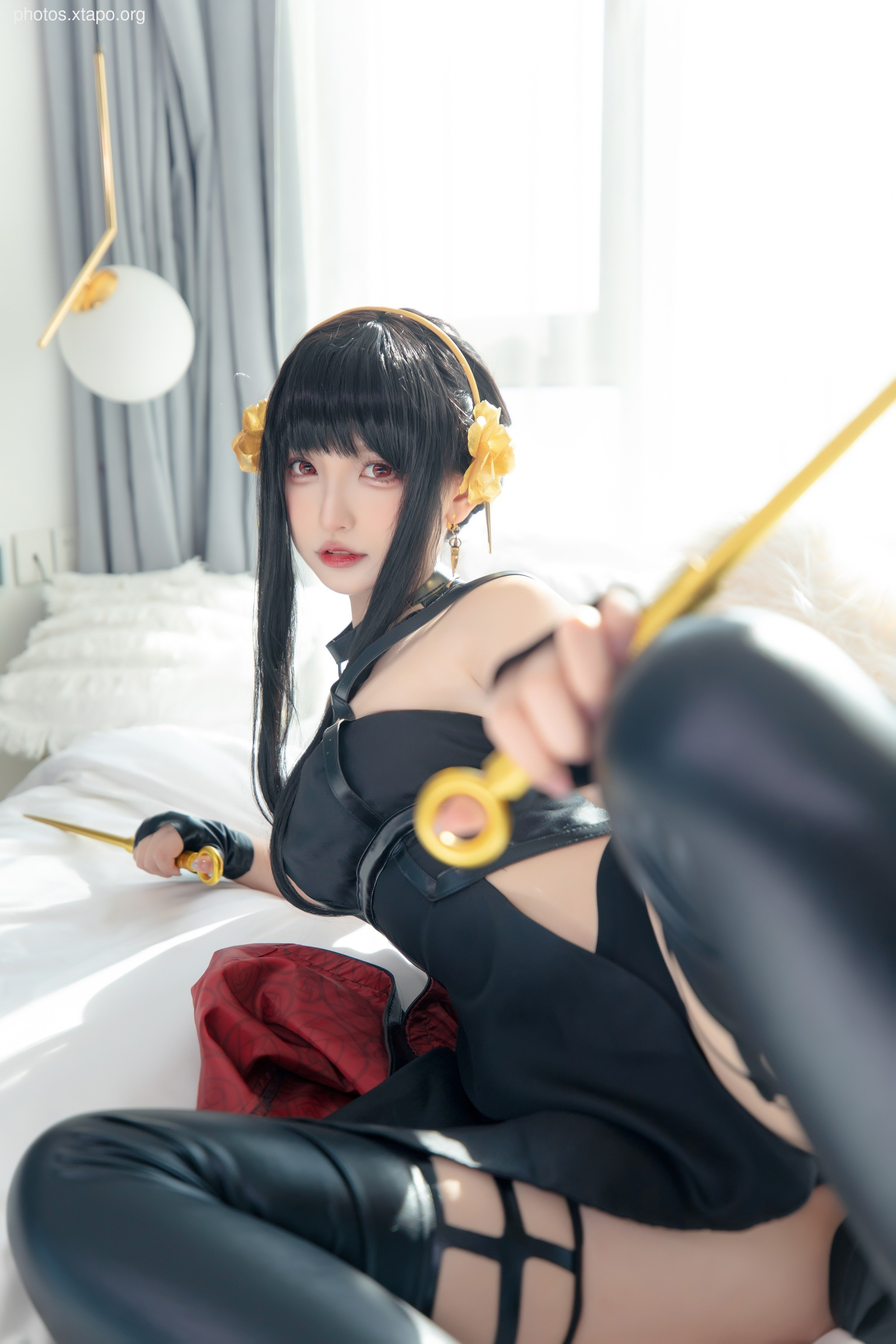 A captivating cosplay portrayal of a dark fantasy warrior, wielding golden weapons.  The model's striking black hair and elaborate costume enhance the dramatic atmosphere.