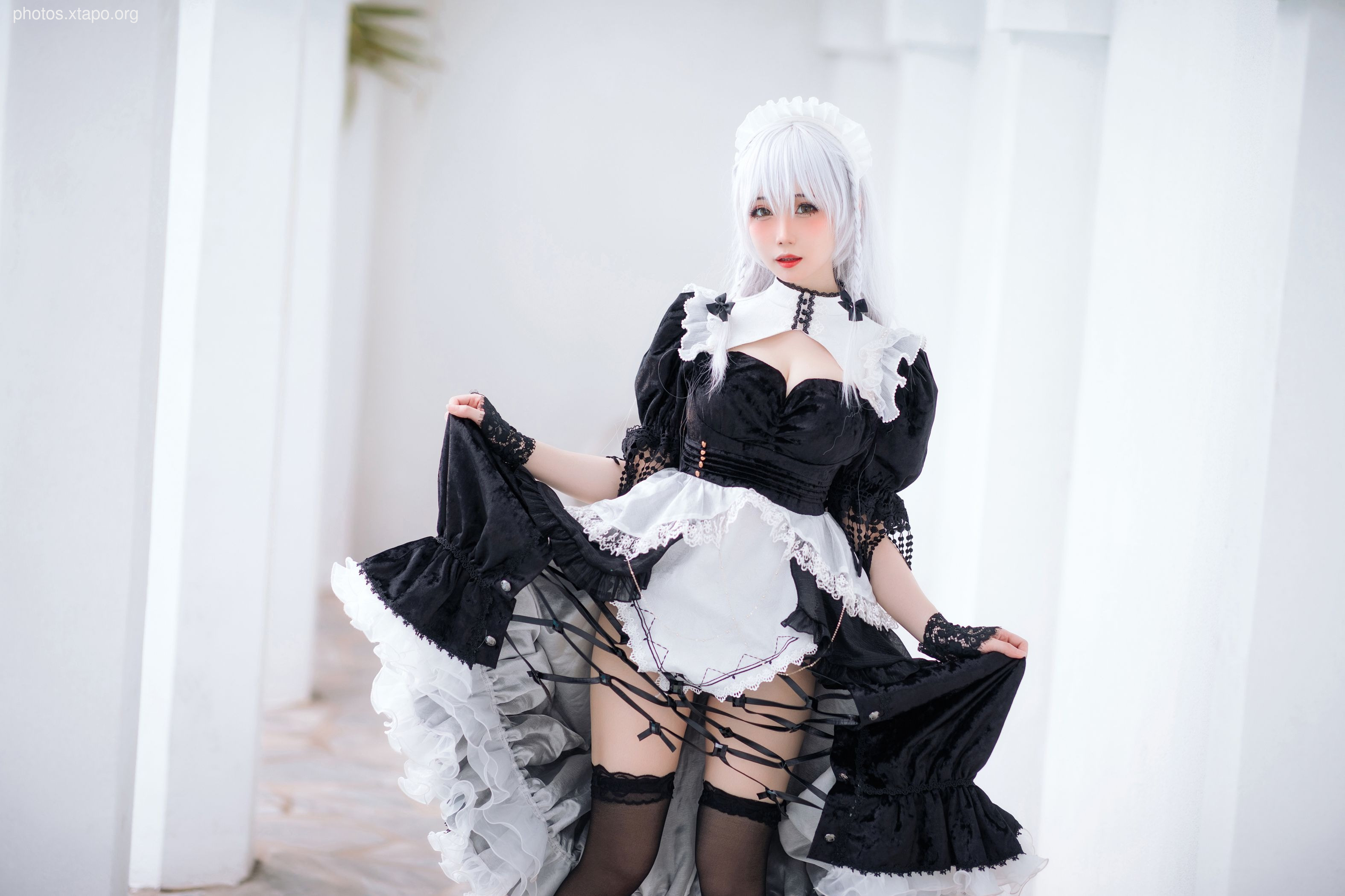 A captivating cosplay portrait of a model dressed as a gothic maid.  The black and white costume features a layered skirt, lace detailing, and a dramatic pose.