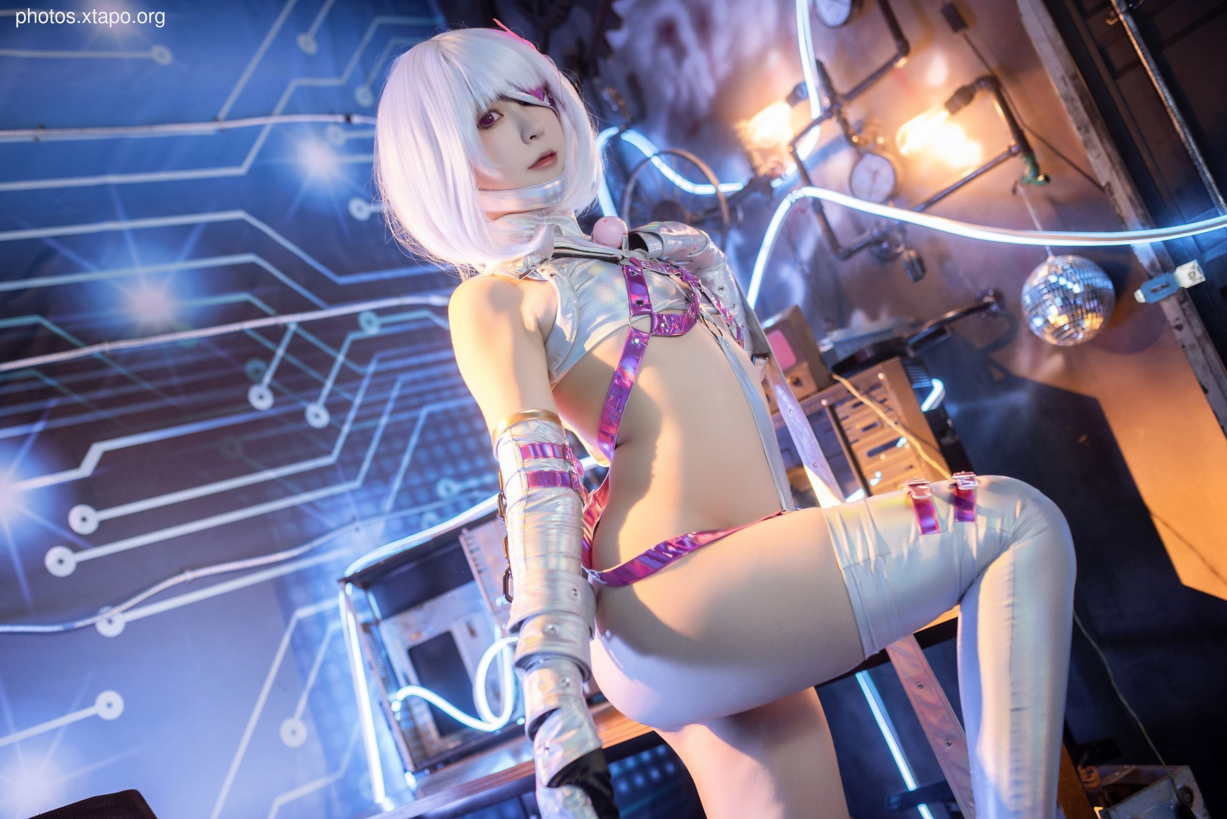 Cosplay of a cyberpunk character in a futuristic setting. The model is wearing a white and purple outfit with silver accents and knee-high boots.