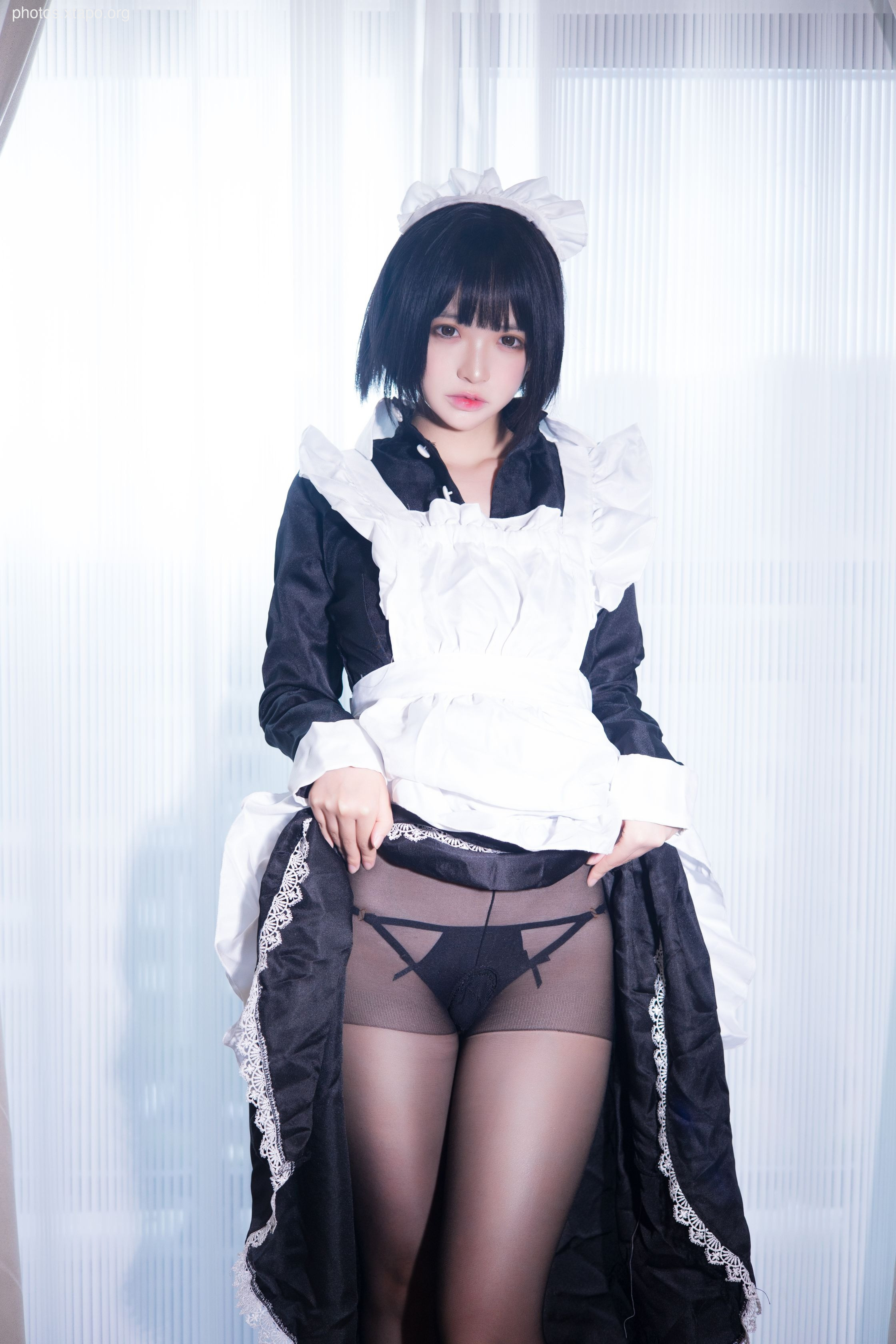 A playful maid in a black and white uniform, showcasing a mischievous peek of her lingerie.