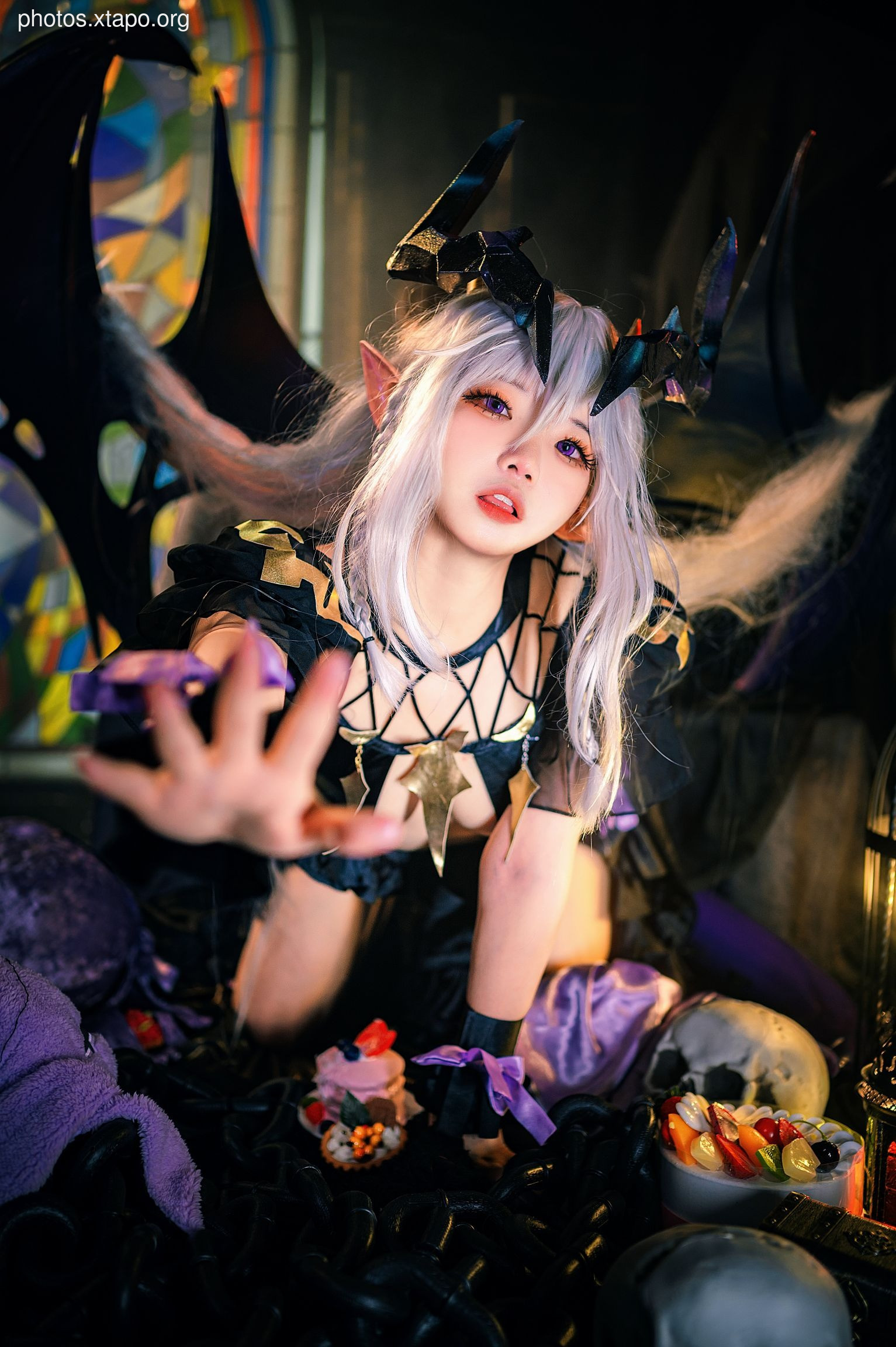 A captivating cosplay portrait of a gothic lolita demoness, adorned with devilish horns and a dark, elegant attire.  The model's expressive pose and detailed costume create a striking visual.