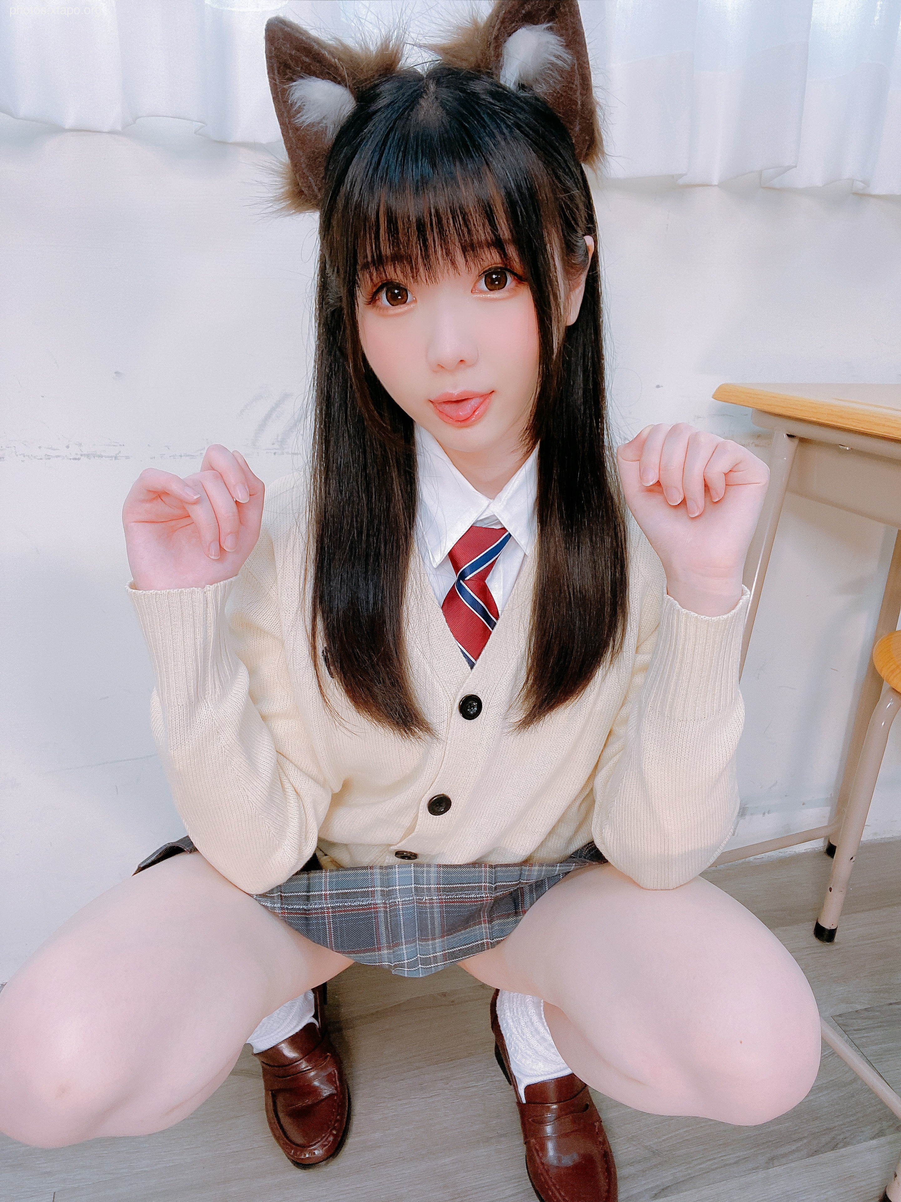 A playful student in a school uniform with cat ears, playfully posing for the camera.