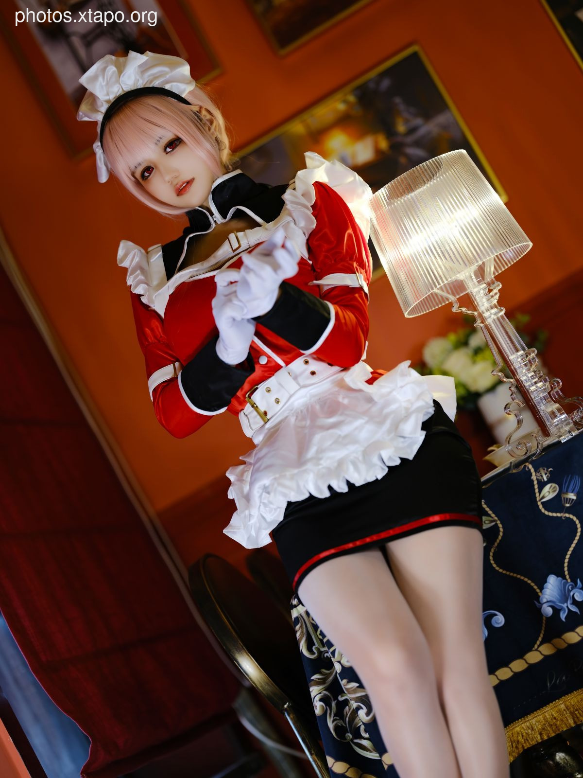 A captivating cosplay of a maid in a striking red and black uniform. The model's pose and attire create a visually stunning image.