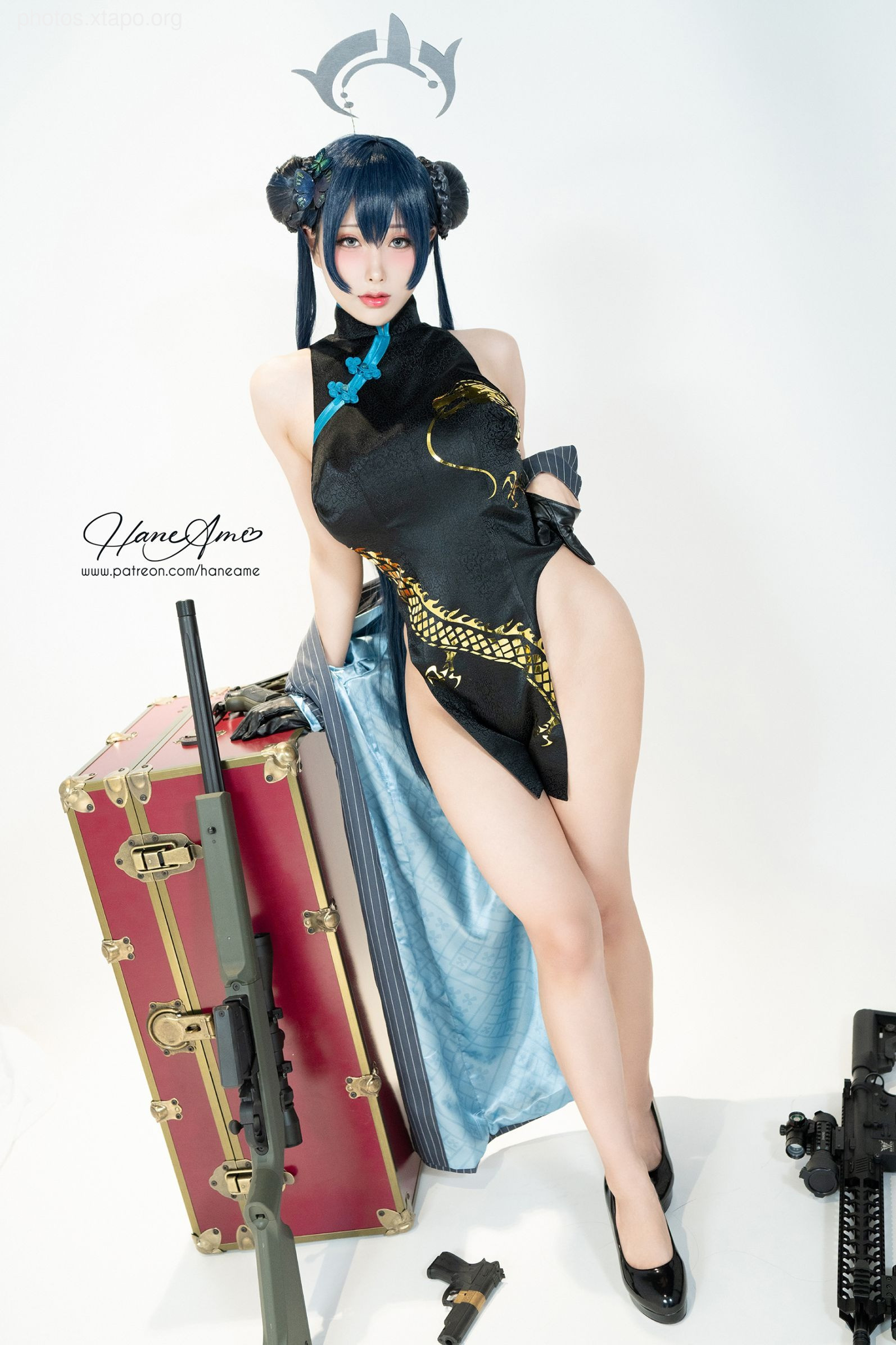 A stunning cosplay of a female agent in a traditional Chinese cheongsam, wielding a rifle and standing beside a vintage suitcase.  The model is expertly portraying a blend of elegance and action.