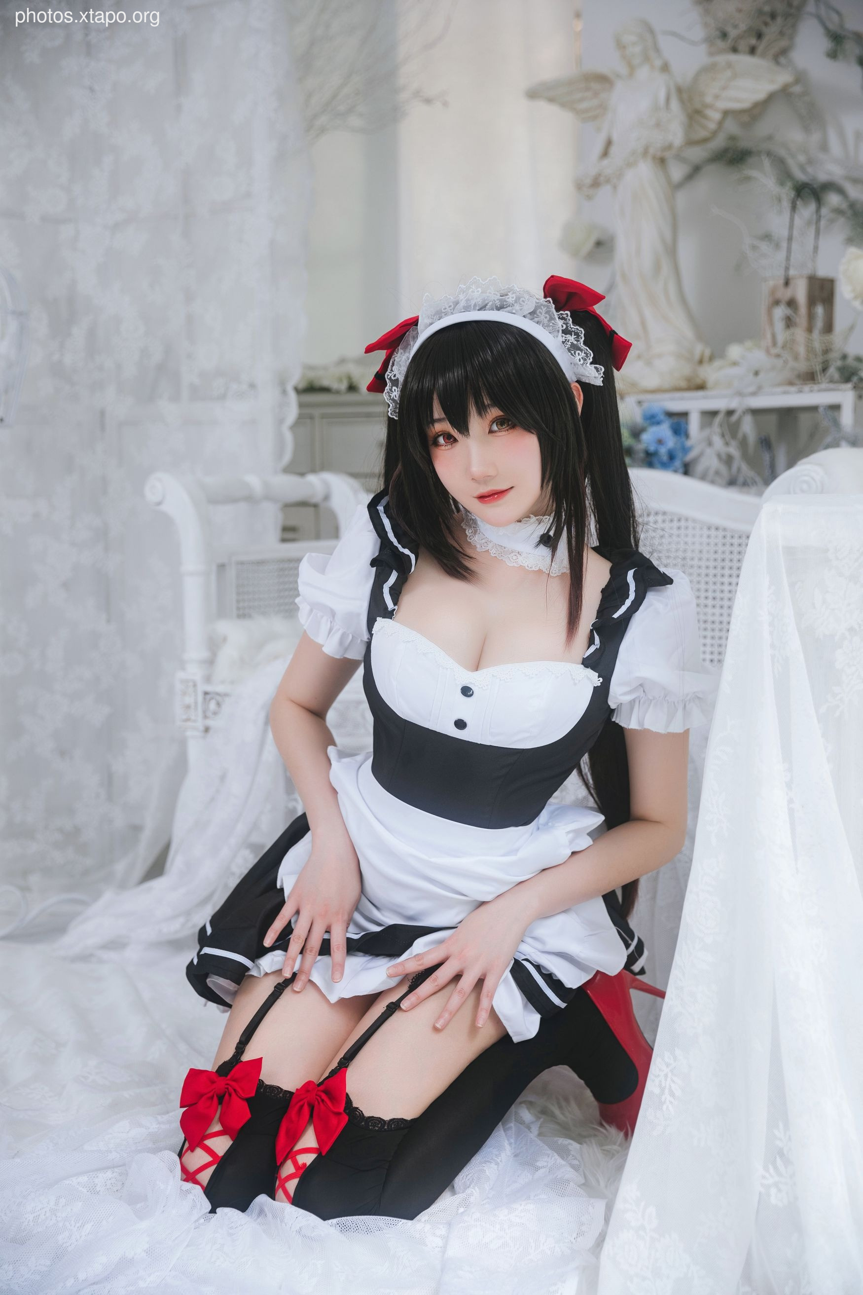 A woman in a maid cosplay costume poses for a photo.
