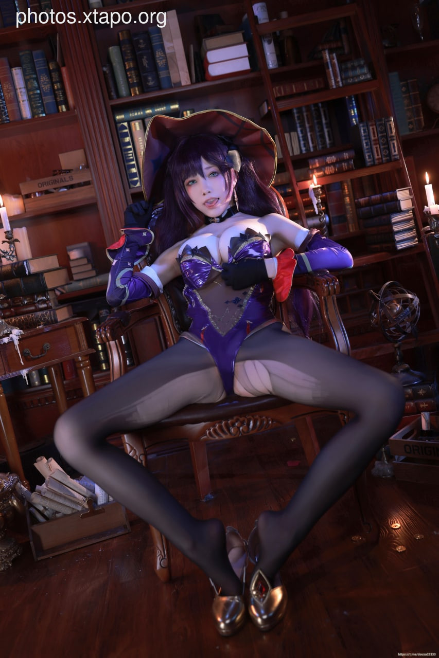 A captivating cosplay photoshoot of a witch in a stunning purple and black costume, posed in a dimly lit library setting.