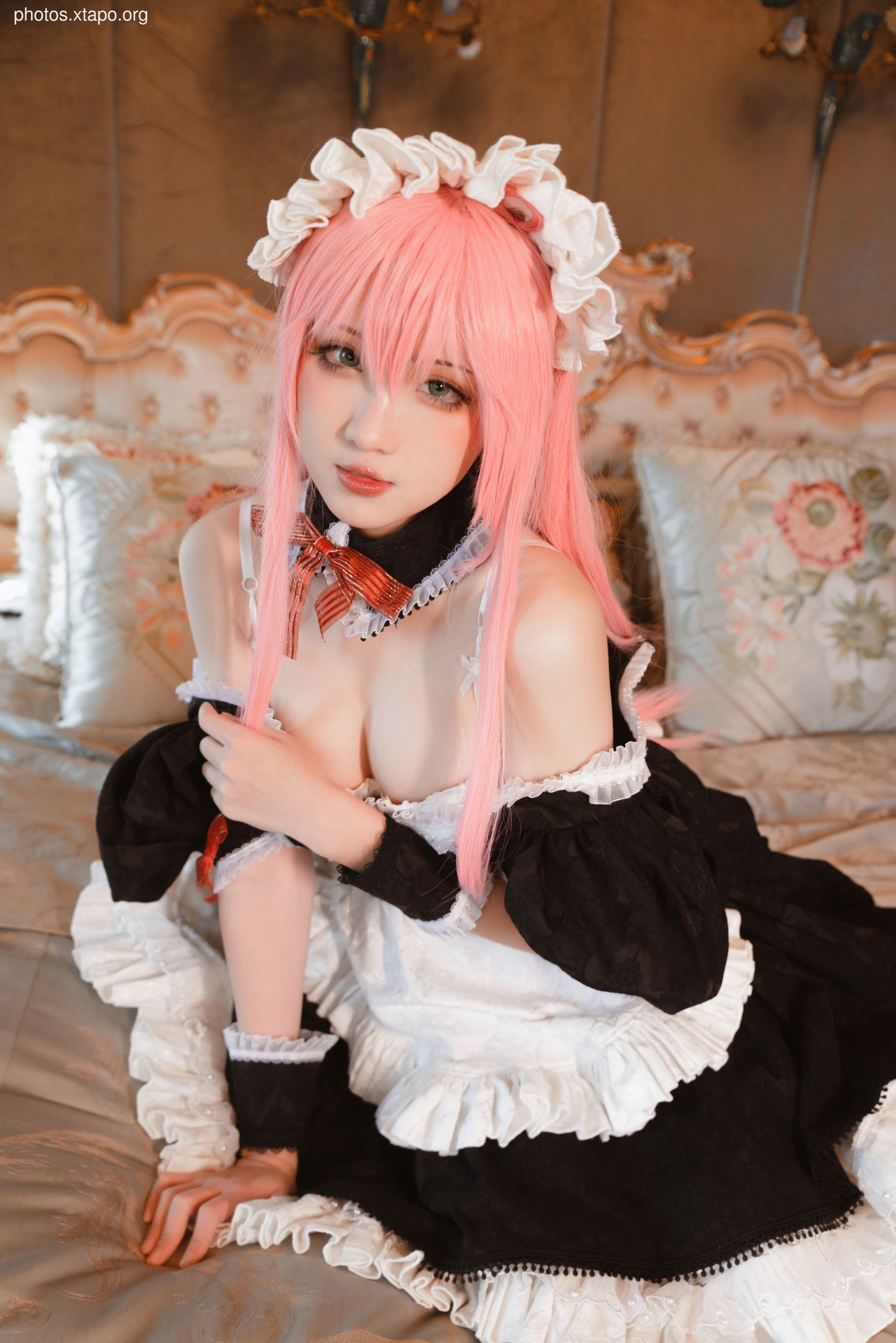 Cosplay of a maid in a black and white dress with pink hair.