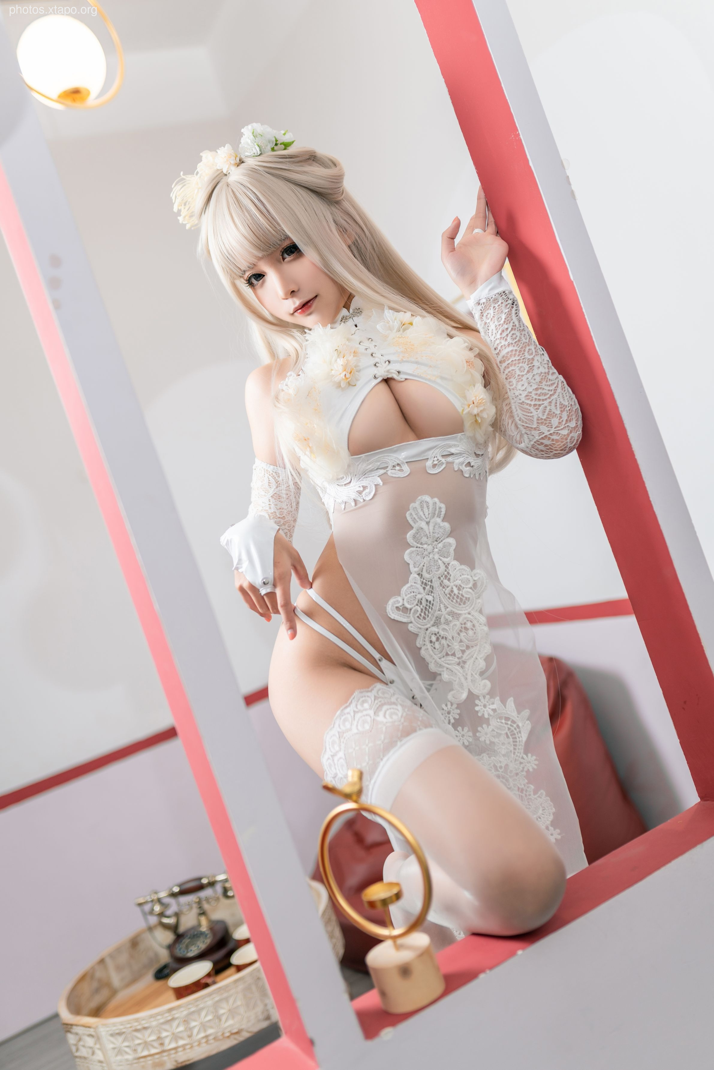A stunning cosplayer in an intricate white bridal qipao.  The sheer lace and delicate embroidery create a beautiful and ethereal look.