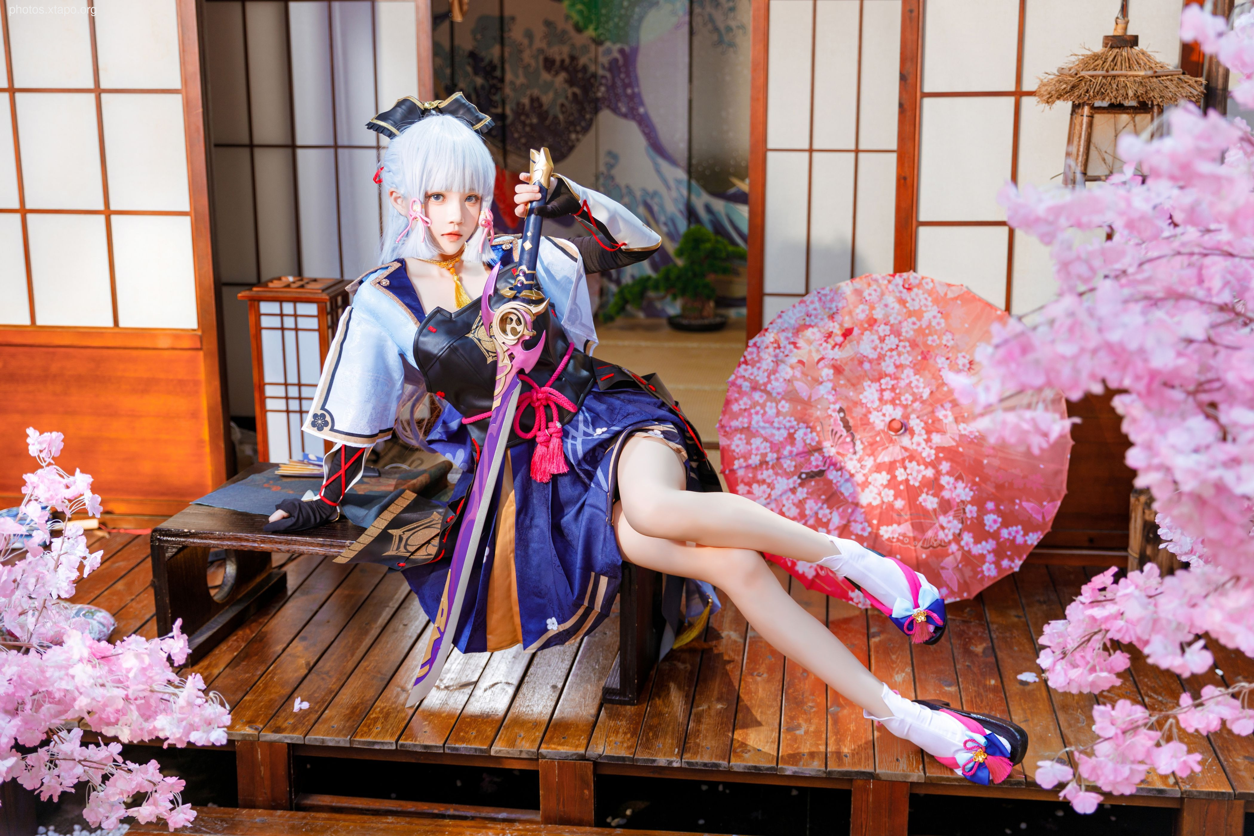 A captivating cosplay portrait of a female warrior, elegantly poised in a traditional Japanese setting. She is adorned in a stunning kimono-inspired outfit, complete with a katana and cherry blossom accents, creating a striking visual.
