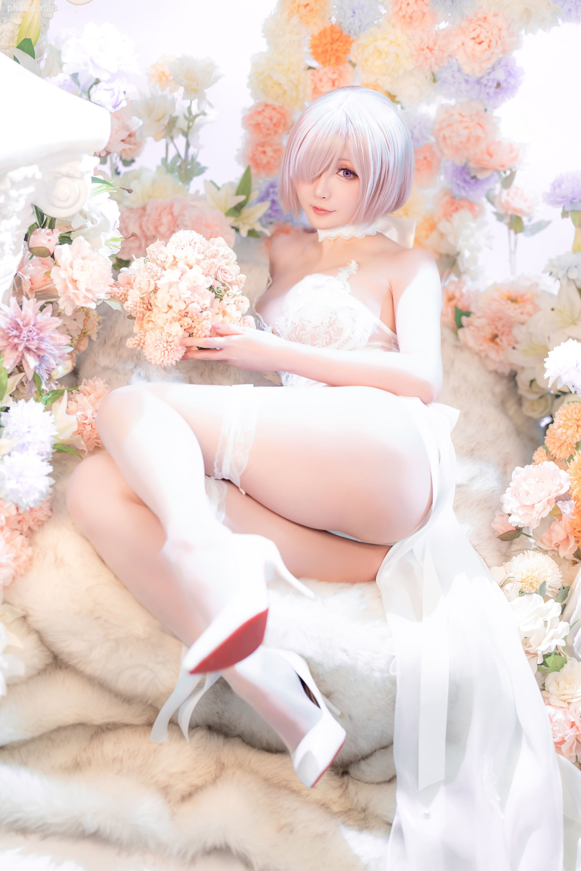 A stunning cosplay photoshoot of a bride in a white dress, surrounded by flowers.