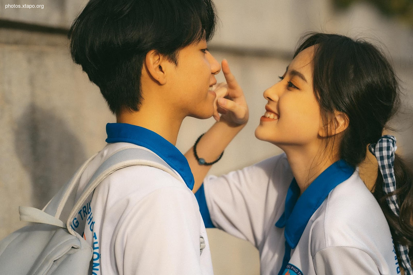 A young couple shares a tender moment, their affection evident in their close embrace.