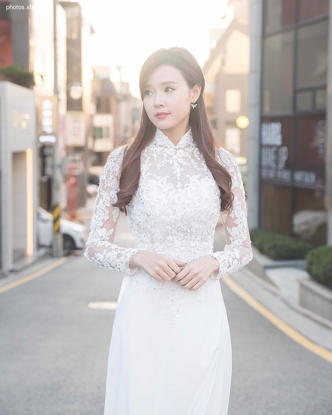 A stunning bride poses in a delicate white lace gown, creating a timeless and elegant bridal portrait.